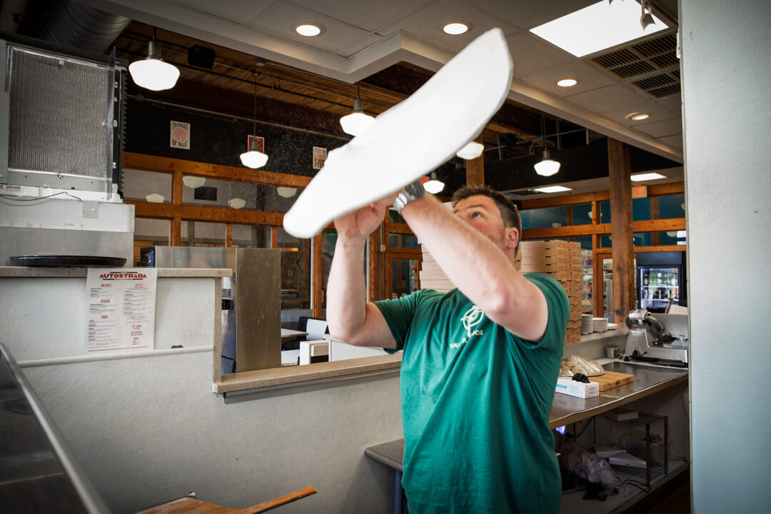 Chef Drew Moore throwing pizza at Autostrada, Carr Mill Mall, NC