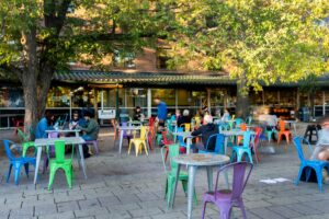 The Weaver Street Market patio at Carr Mill Mall in Carrboro, NC, where neighbors gather for coffee, lunch, and weekend jazz brunch.